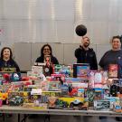 People stand in front of table of donated toys