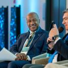 Chancellor Gary S. May looks on as David Garza speaks