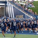 Members of the football team run onto the field