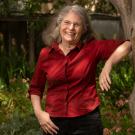 Wendy Kuhn Silk, smiling, leaning against tree