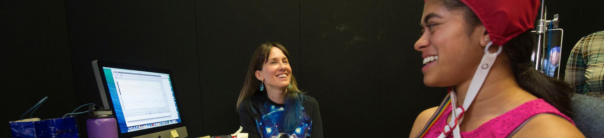 A student has her brainwaves measured by a researcher