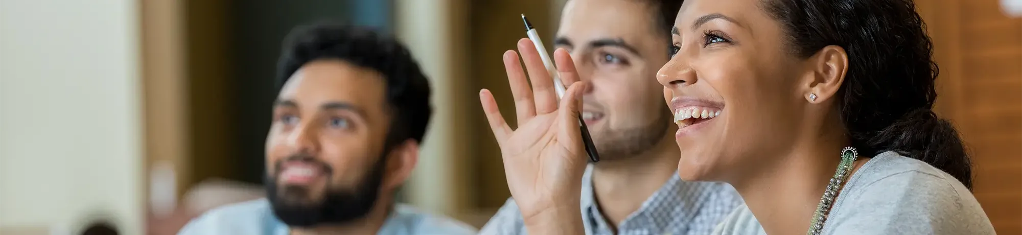 Three students listening attentively to a speaker