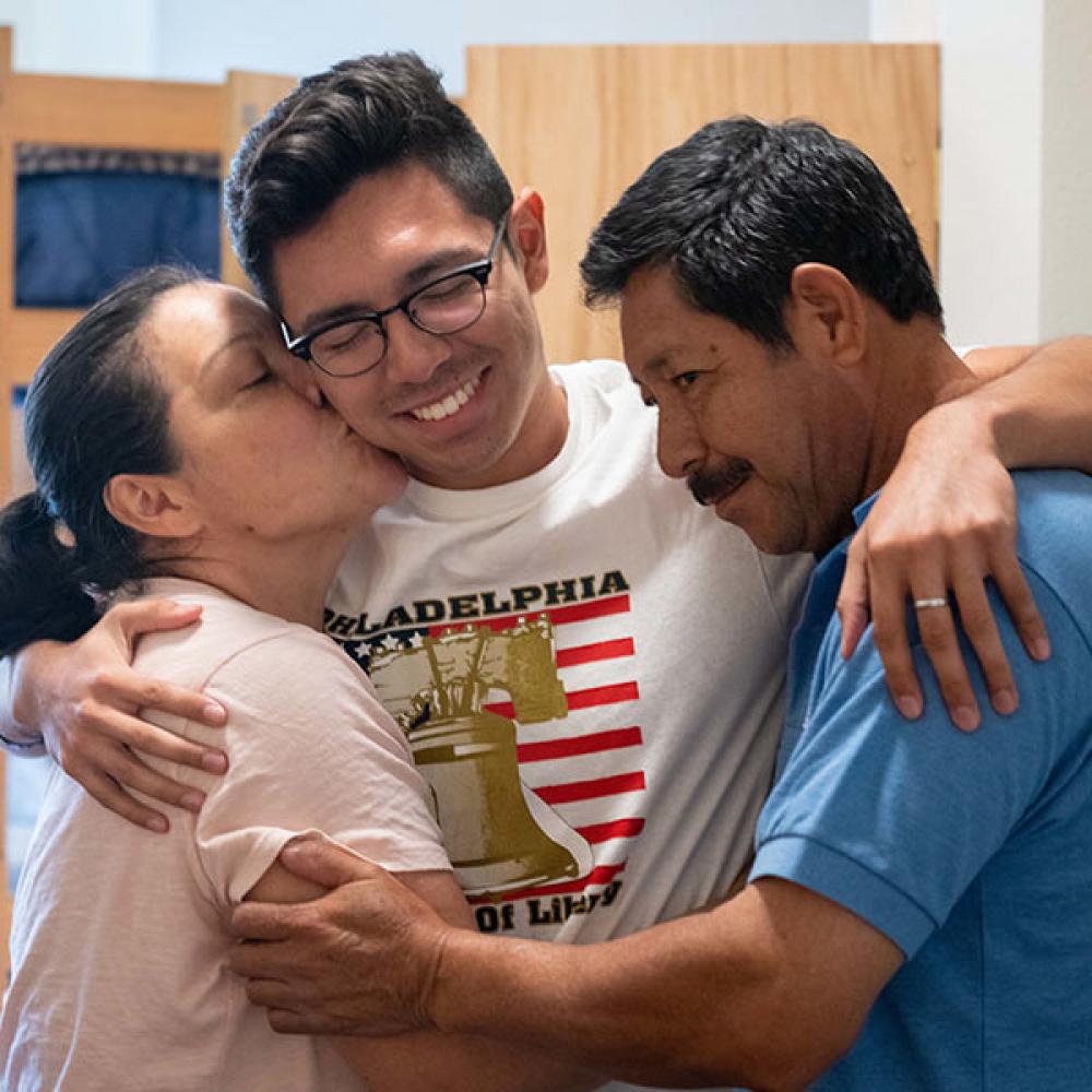 student hugs parents at move in day