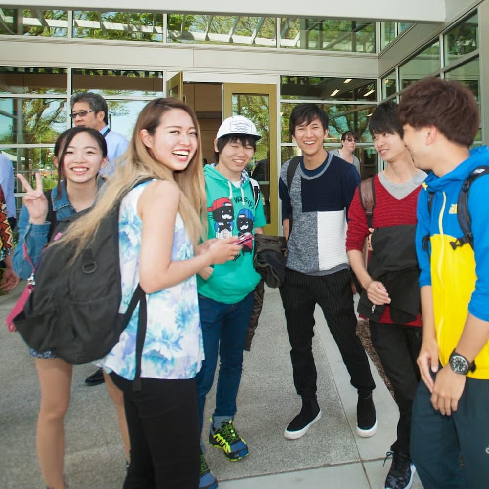 Students gathered in front of building socializing 