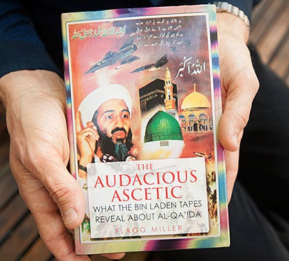 Hands holding a book titled "The Audacious Ascetic