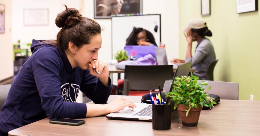 Students in deep concentration at small desks in bright room
