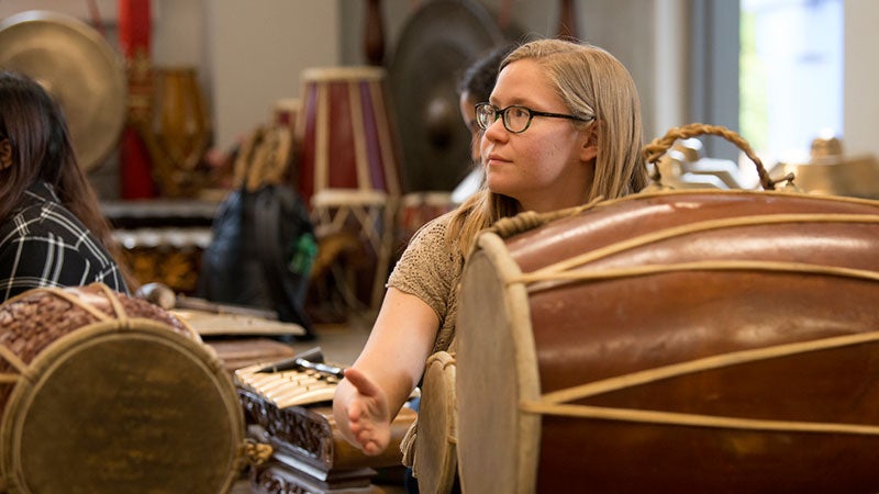 A woman plays a drum