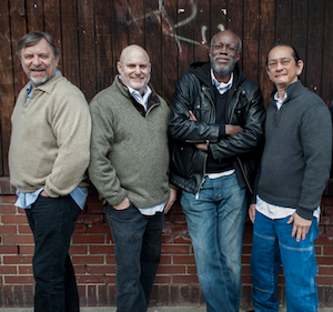Members of the quartet standing in front of a wall.