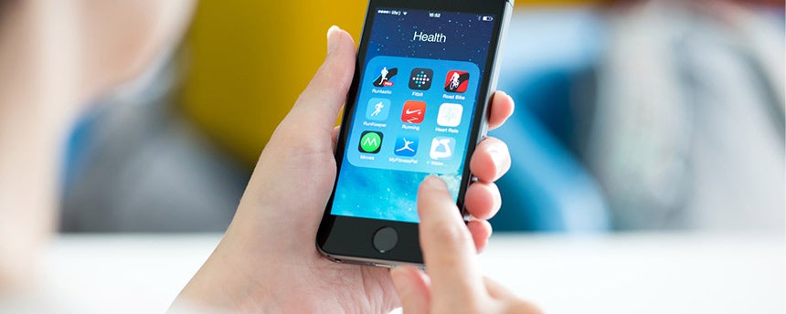 Woman's hands hold cell phone with health apps on screen.