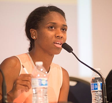 A woman speaks into a microphone
