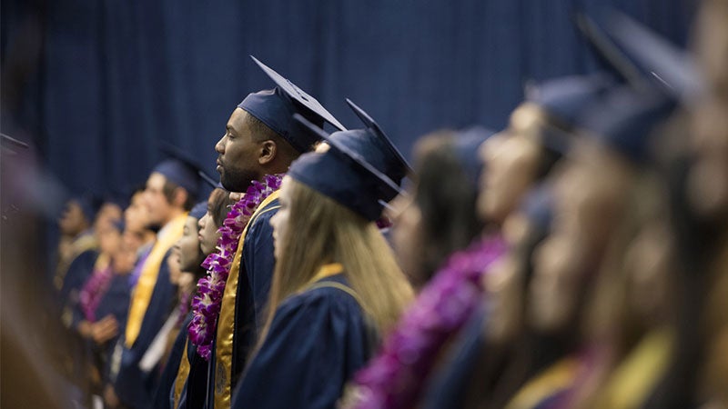 Students stand during an undergraduate commencement ceremony. (Credit?/UC Davis)