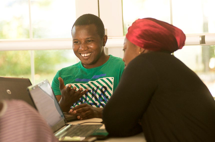 A man and woman at table with computers