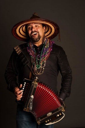 A photo of Terrance Simien holding an accordion.